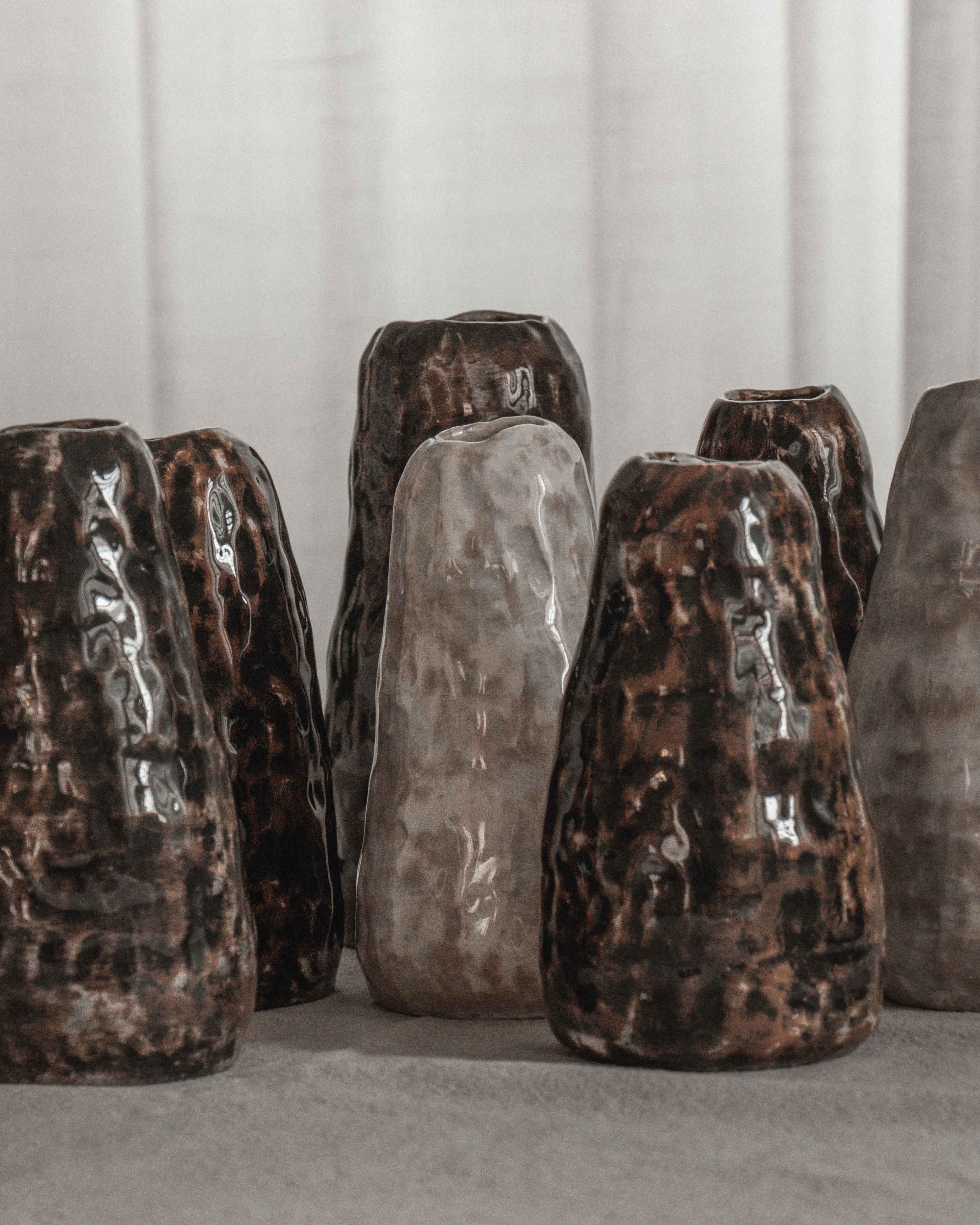 Set of six ceramic vases with textured surfaces on a neutral background