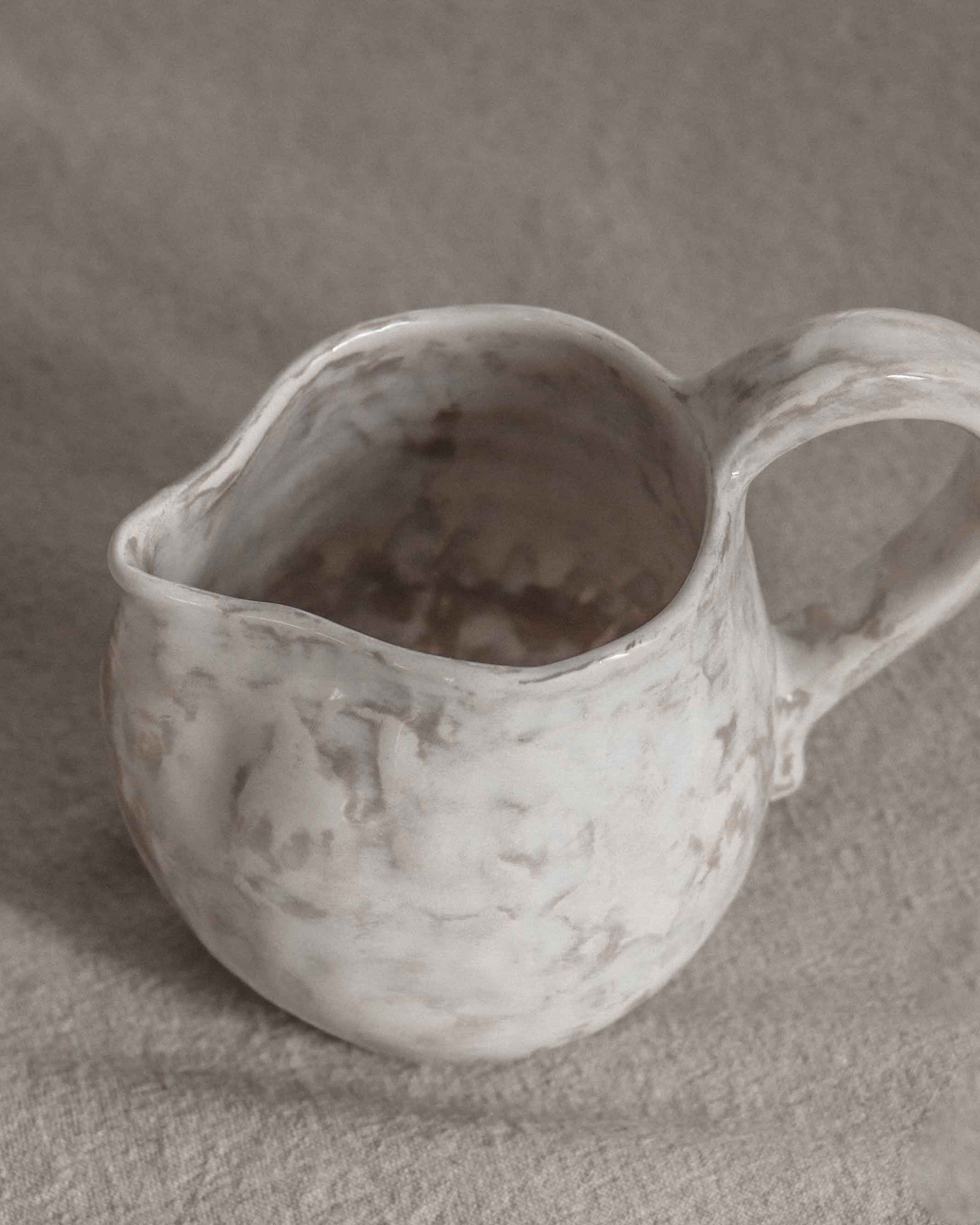 White ceramic pitcher on a gray background