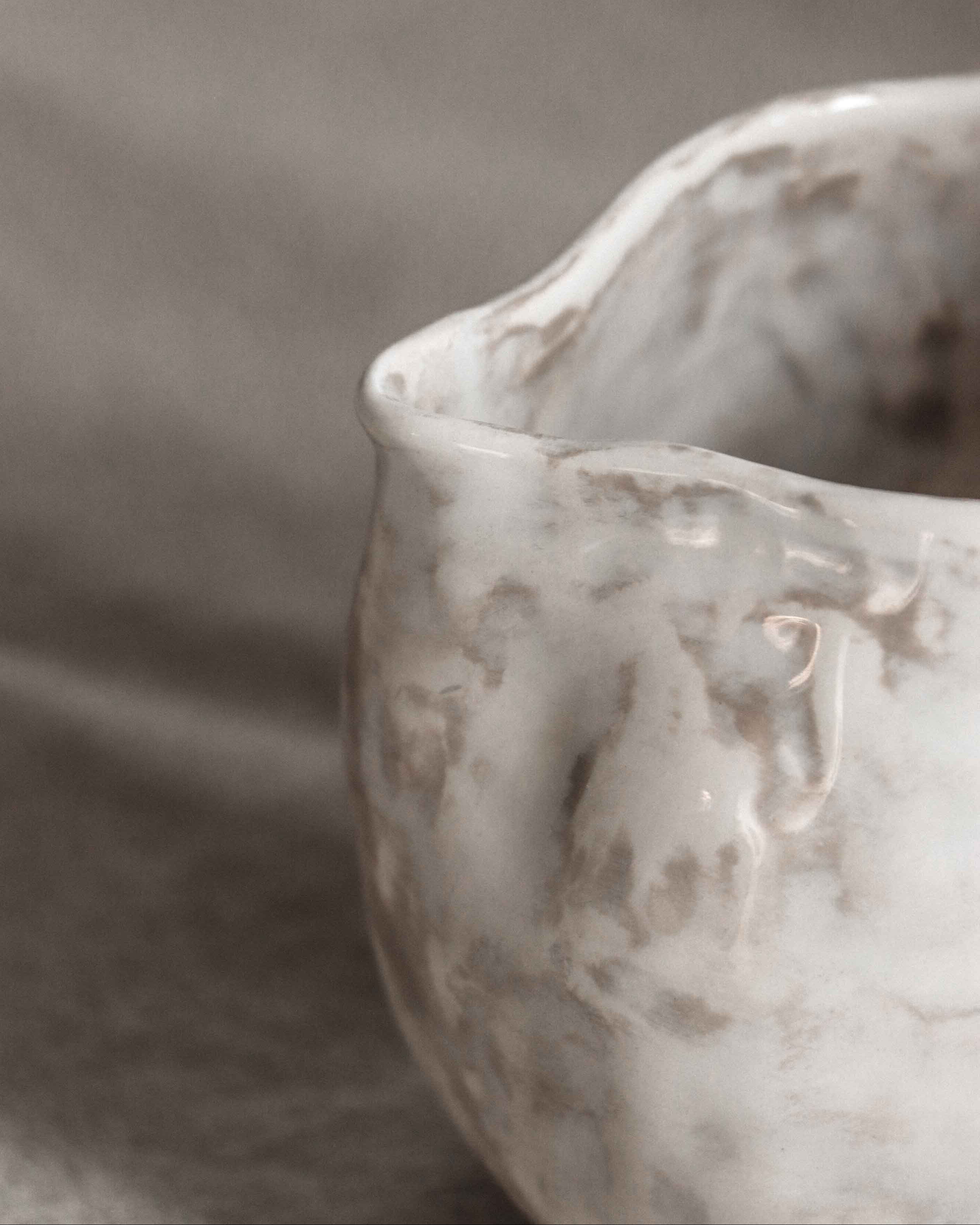 Close-up of a textured ceramic bowl on a gray background