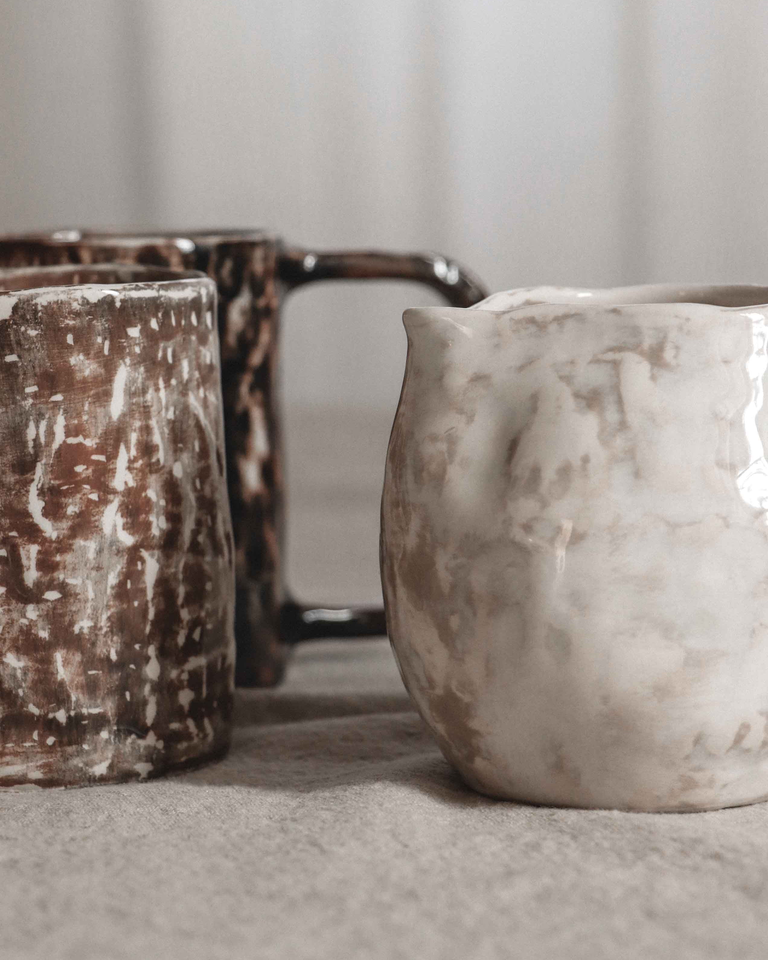 Two ceramic pots with textured surfaces on a neutral background