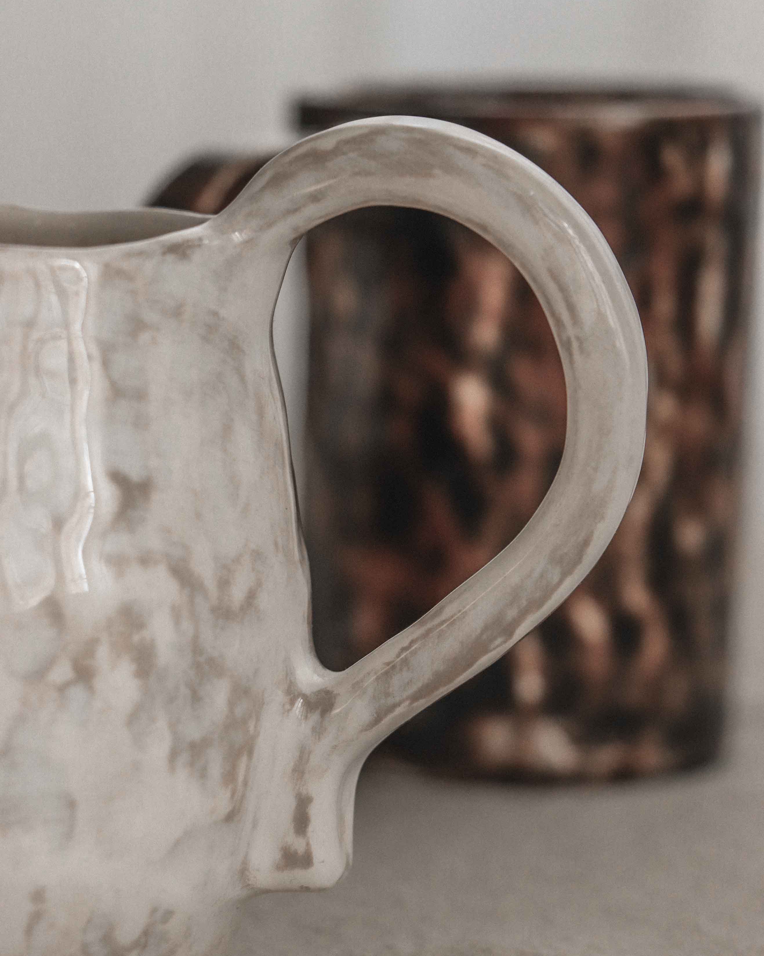 Close-up of a textured ceramic mug with a blurred background