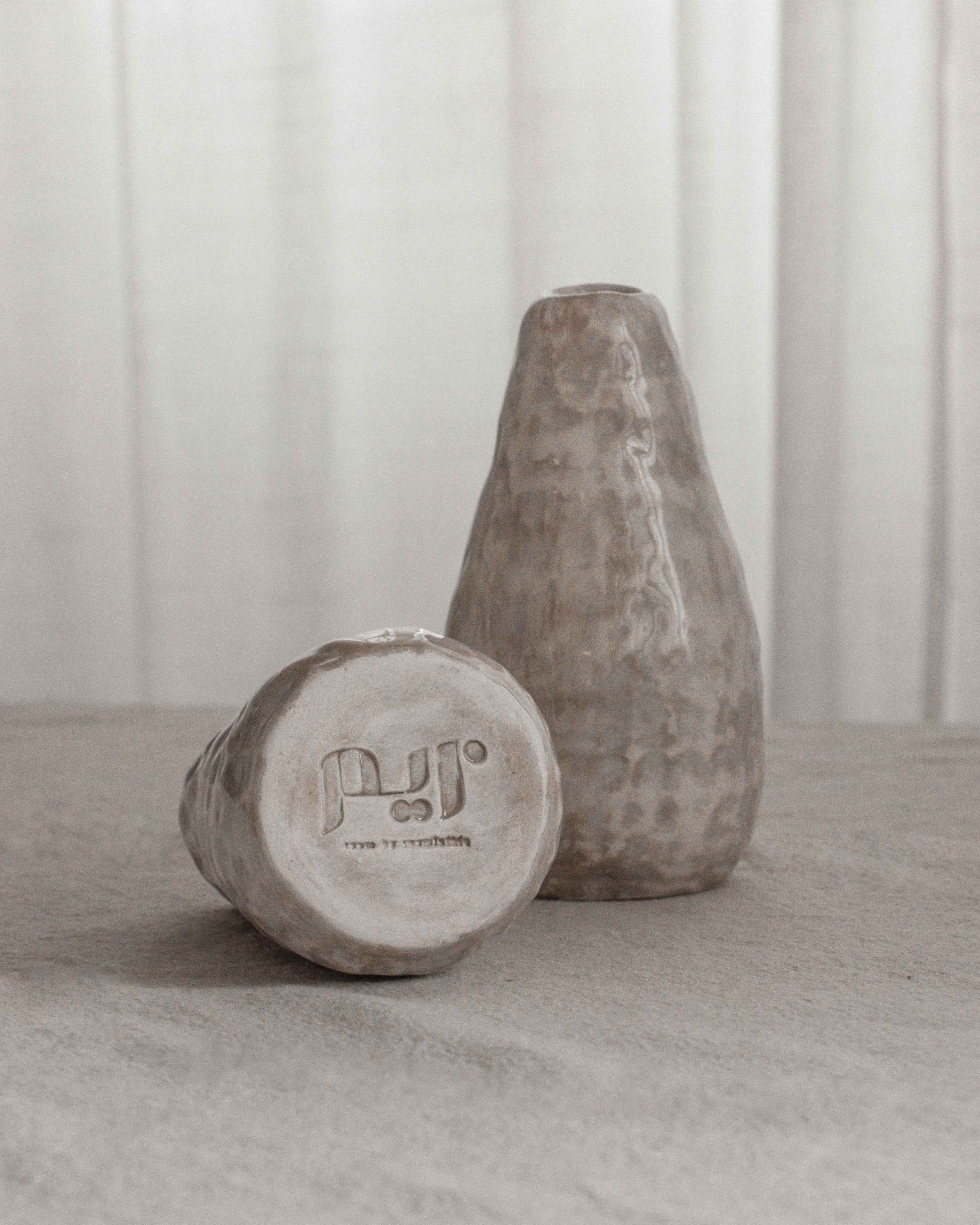 Two concrete weights on a light surface with a neutral background