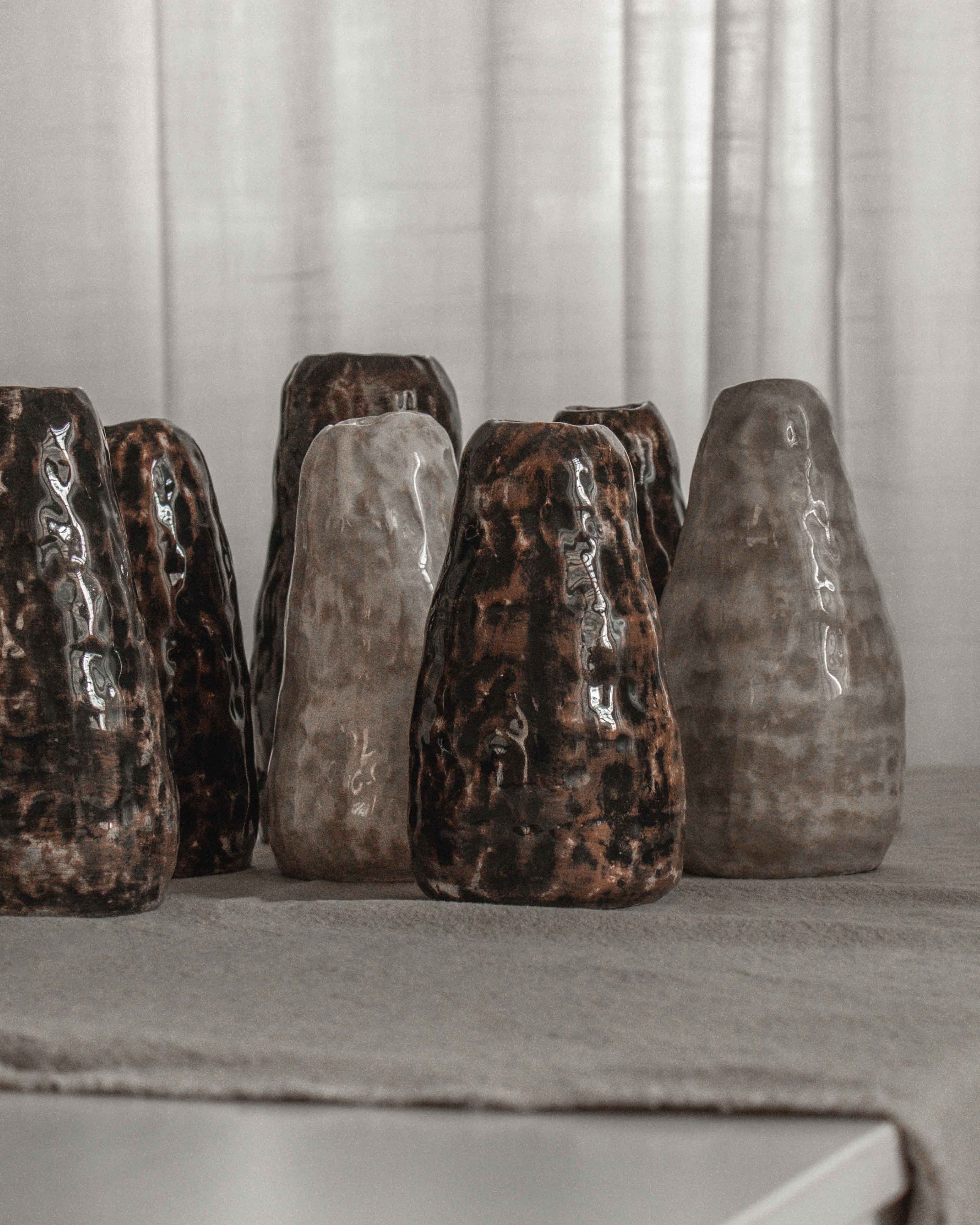 Set of six ceramic pots on a table with a neutral background